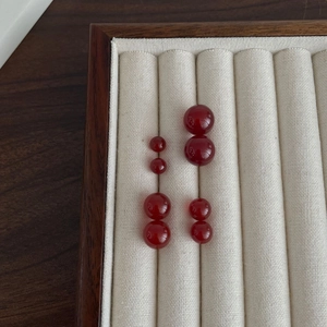 Elegant S925 silver red agate stud earrings set in four sizes on beige velvet tray