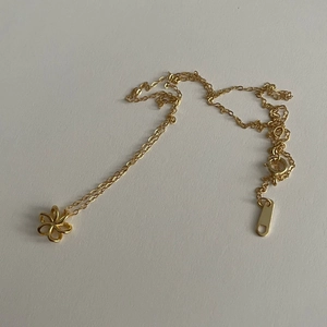 Détail du collier à fleurs dorées avec pendentif à six pétales et chaîne en O ajustable