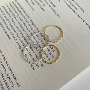 Detailed view of four S925 sterling silver hammered texture rings on a book background