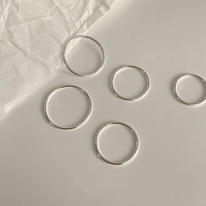 Detail showing five minimalist polished 1.2mm sterling silver bands on aesthetic background