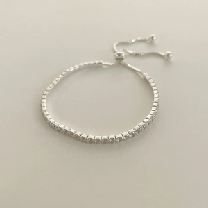 Macro view of silver S925 sterling silver tennis bracelet with adjustable bolo clasp
