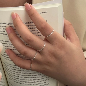 Set of four minimalist S925 sterling silver ultra-thin stackable bands on a hand