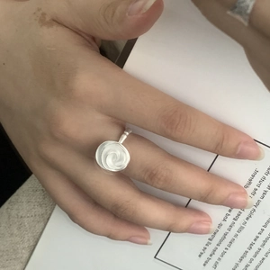 Gros plan d'une bague rose en argent S925 avec texture brossée sur un doigt mannequin