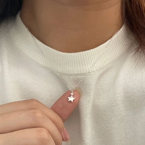 Minimalist S925 sterling silver star pendant necklace shown on a female model neck