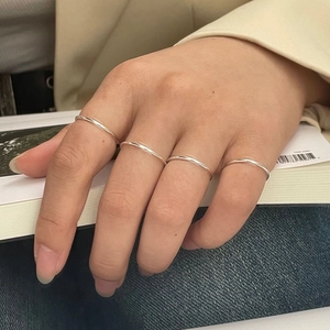 Close-up of four minimalist 925 sterling silver stacking rings worn on fingers