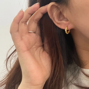 Créoles torsadées dorées en argent S925 portées par un mannequin pour un style élégant