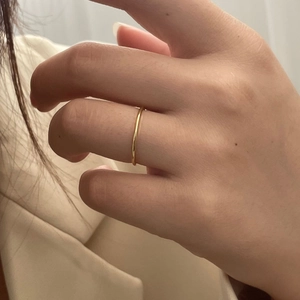 Close-up of a 1.2mm minimalist gold-plated silver thin ring worn on a finger