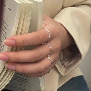 Set of four minimalist 925 sterling silver thin rings worn for a layered lifestyle look