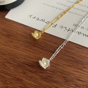 Detaillierte Makroansicht von Muschelperlenanhängern in Gold und Silber mit feinen Perlenketten