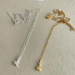 Detailed close-up of S925 sterling silver and gold star necklaces with zircon accents