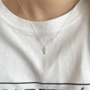 Minimalist S925 sterling silver necklace with small fish pendant worn on a model