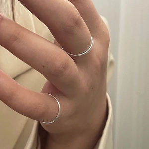 Close-up of minimalist S925 sterling silver thin stackable rings on woman's fingers