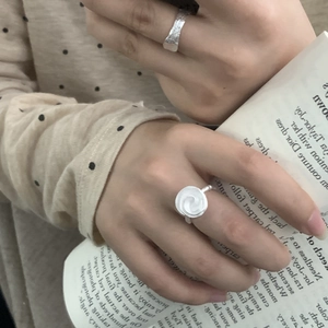 Détail d'une bague rose en argent S925 et d'un anneau texturé porté sur la main