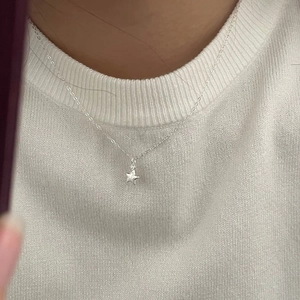 Close-up of S925 sterling silver star pendant necklace with cubic zirconia on model