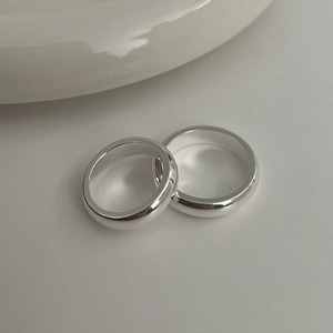 Close-up of dual polished S925 silver rings with smooth minimalist rounded design
