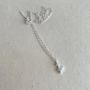 Macro detail of S925 sterling silver star necklace showing hallmark stamp and zirconia