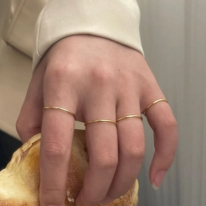 Set of four minimalist 1.2mm gold-plated silver thin bands worn on model fingers