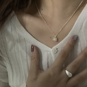 Nahaufnahme der S925 Silberkette mit Muschelperle und passendem Ring am Modell getragen