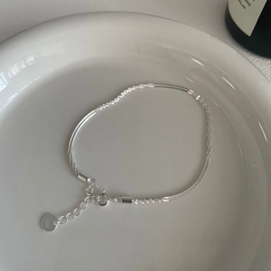Detailed macro view of S925 sterling silver bracelet chain with spring clasp and logo tag