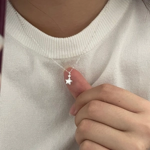 Detail of S925 sterling silver star pendant with cubic zirconia on a dainty chain