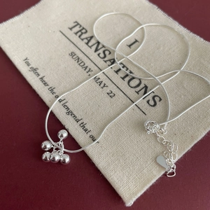 Detail view of S925 sterling silver ball pendant necklace on a beige linen pouch