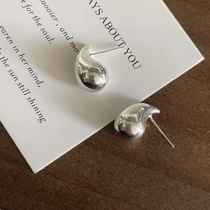 Detail view of S925 sterling silver teardrop earrings with a polished metallic finish