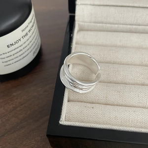 Detail view of multilayer sterling silver adjustable ring on a jewelry storage box