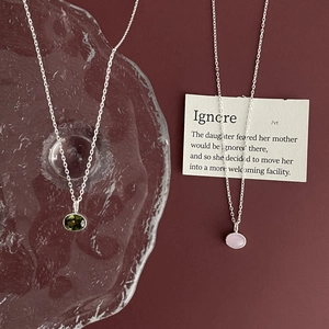 925 sterling silver necklace with oval olive green and pink gemstone pendants on burgundy background