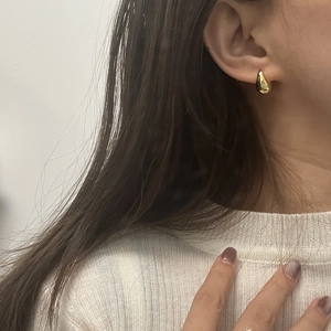 Minimalist 925 sterling silver drop earrings with polished gold finish on female model