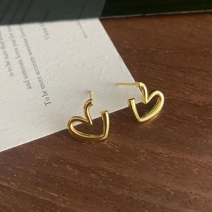 Minimalist gold S925 silver hollow heart stud earrings on a vintage aesthetic card