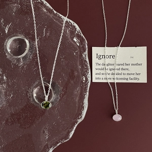 Detail of 925 sterling silver necklaces with green and purple oval zircon pendants