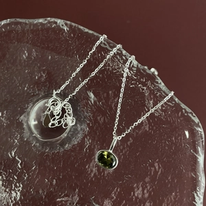 925 silver necklace with green oval gem on textured glass background for women