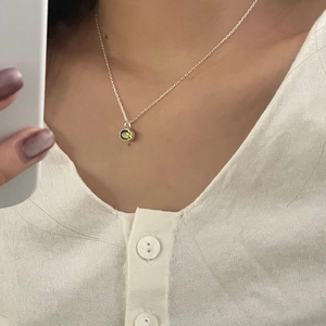 925 Sterling Silver necklace with oval green zircon pendant worn on minimalist white shirt