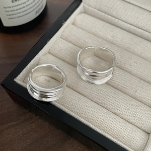 Close-up of minimalist S925 sterling silver rings with pleated texture in a jewelry box