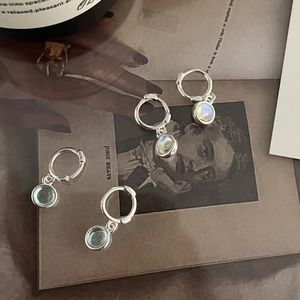 Elegant S925 silver hoop earrings with moonstone and aquamarine gems on a vintage book