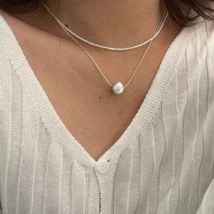 Détail du collier double rang en argent S925 avec perle en métal brossé et chaîne fine