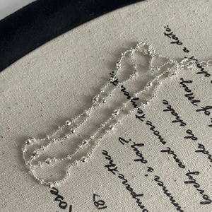 Detail view of S925 sterling silver beaded necklace on textured vintage cloth