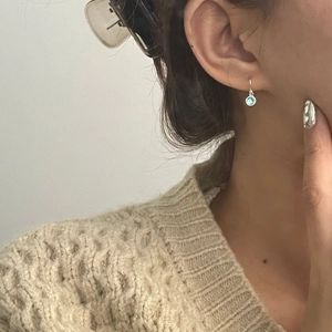 Minimalist S925 silver drop earrings with light blue gemstone shown on a model