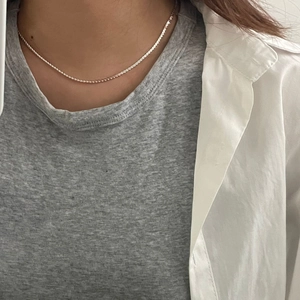 Detailaufnahme einer minimalistischen S925 Silber Schlangenkette am Hals getragen