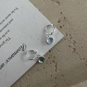 Close-up of S925 sterling silver hoop earrings featuring light blue round gemstones