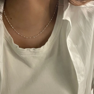Close-up of minimalist S925 sterling silver beaded choker necklace worn on neck