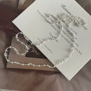 Close-up of S925 sterling silver beaded necklace with faceted beads on silk background