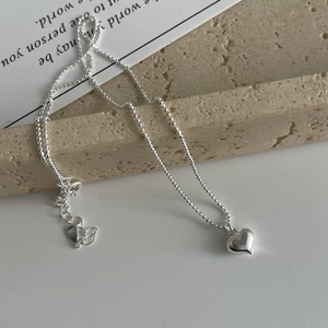 Détail macro du collier cœur en argent sterling S925 avec poinçon et chaîne à billes