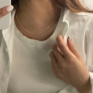 Detailed view of an S925 sterling silver beaded necklace worn on a woman's neck