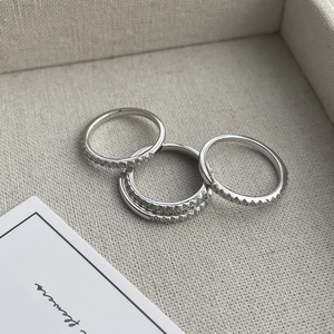 Macro shot of three stacked 925 silver rings with delicate micro-pave cubic zirconia