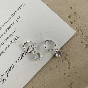 Close-up of S925 silver hoop earrings with translucent moonstone pendants on a white card