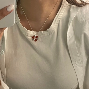 Close-up of S925 silver necklace with red agate beads and silver balls on a model