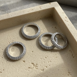 Detailed close-up of four 925 sterling silver rings with micro-pave white zircon stones