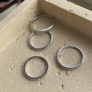 Detail of S925 sterling silver stamp and micro-inlaid zircon stones on stacked rings