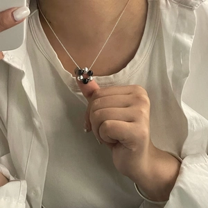 Macro detail of a minimalist S925 silver necklace with black and silver beads on a model